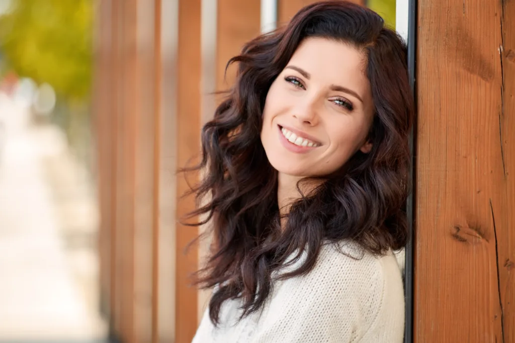 Smiling woman with long dark wavy hair