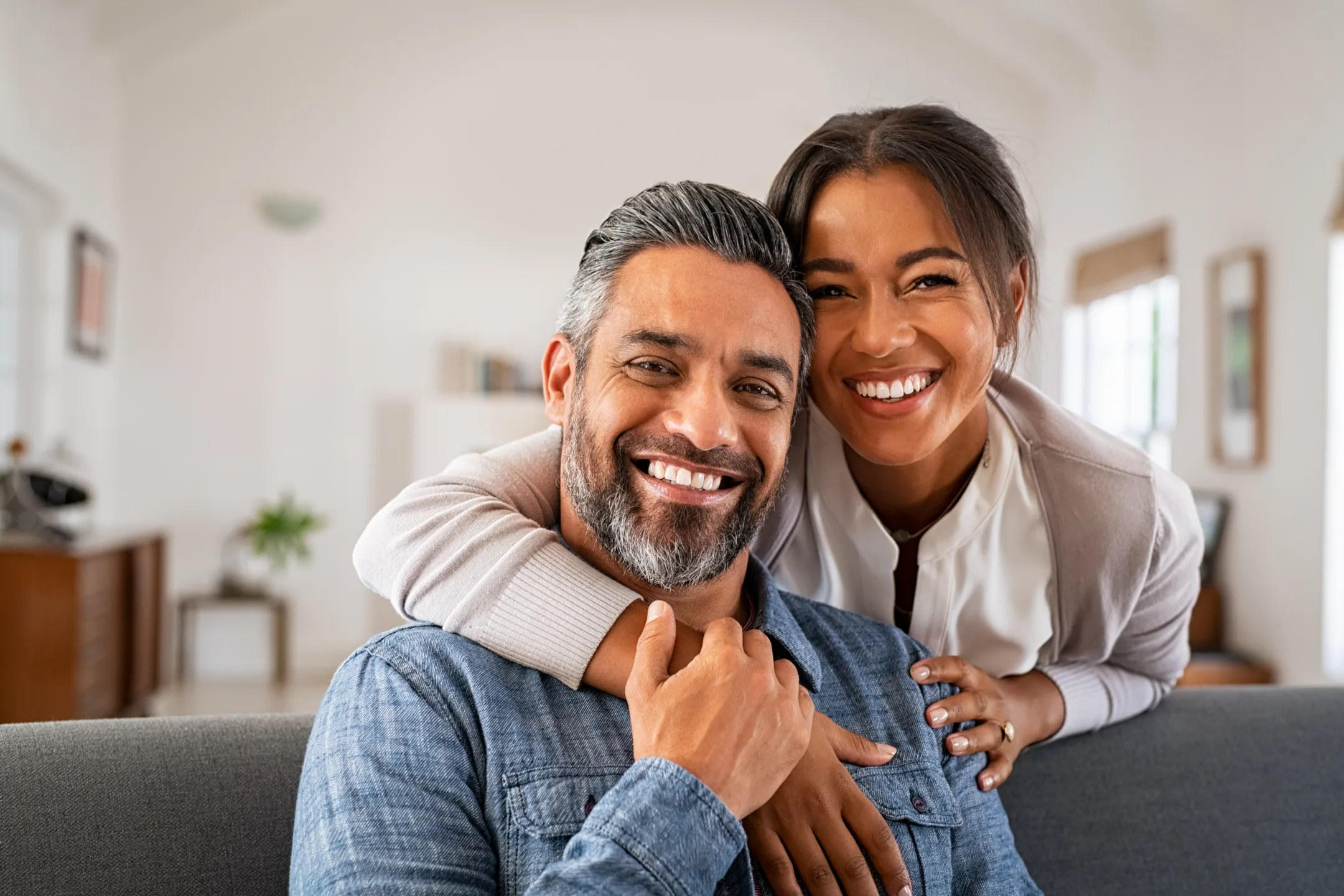 Smiling couple embracing on a couch